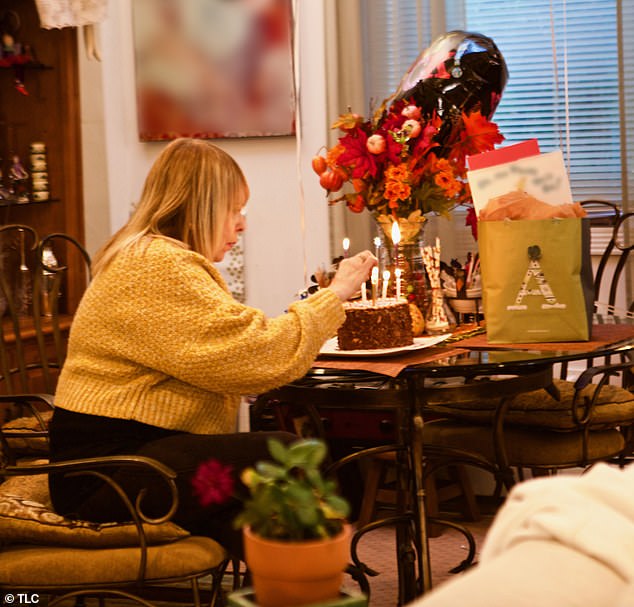 Marcia (pictured) lights candles on a cake to celebrate Alena