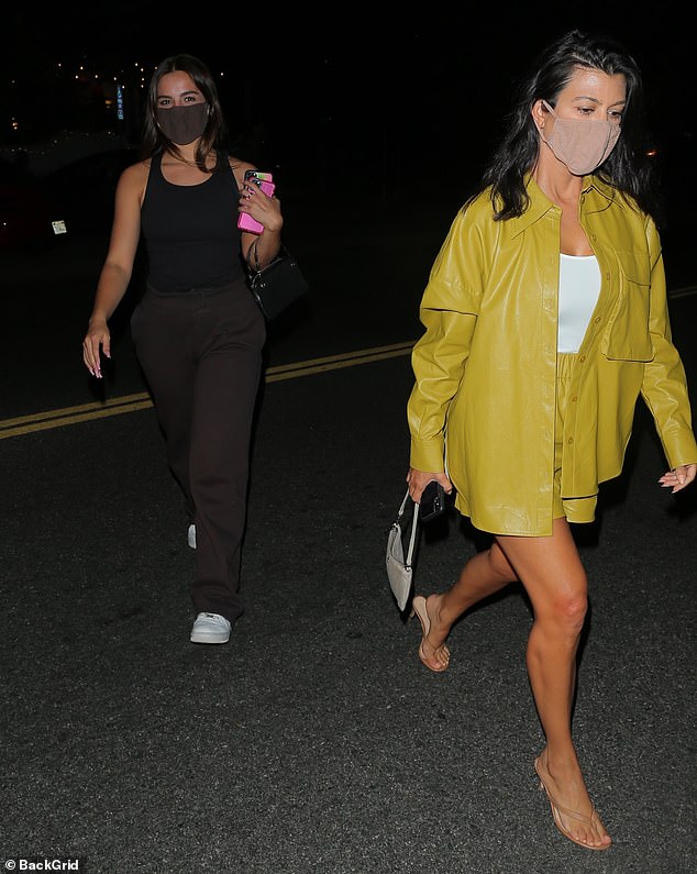 Stunning: Kourtney Kardashian put on a leggy display in a mustard yellow leather jacket and shorts as she stepped out with chic pal Addison Rae after dinner in Malibu on Sunday