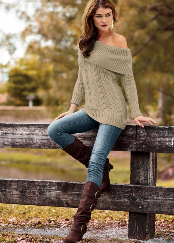 Девушка в свитере с открытыми плечами и джинсах