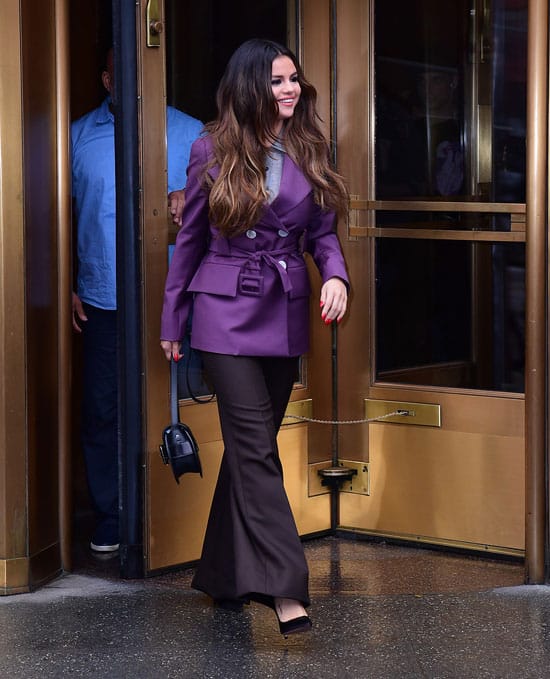Селены Гомес в фиолетовом пиджаке и черных брюках клеш