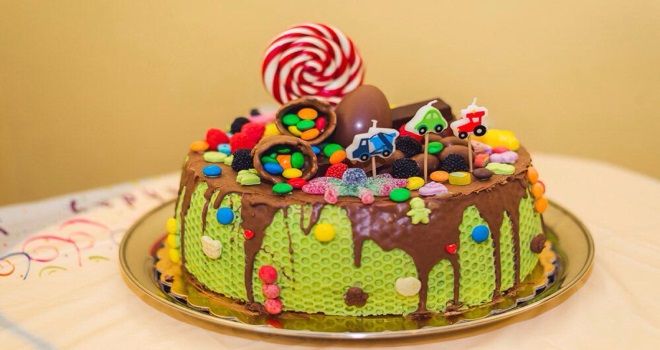 Украшение детского торта шоколадной глазурью драже, мармеладом и топперами