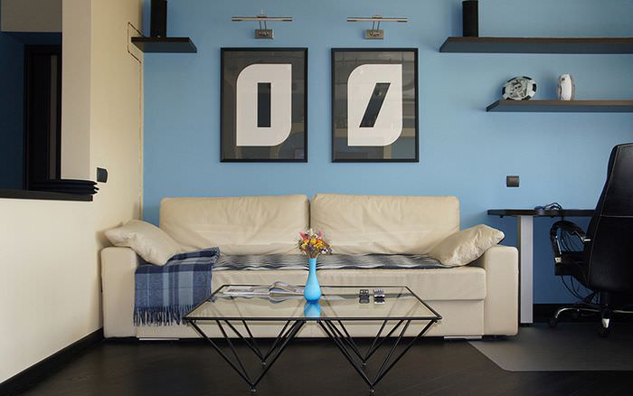Декорирование голубой стены гостиной двум картинами