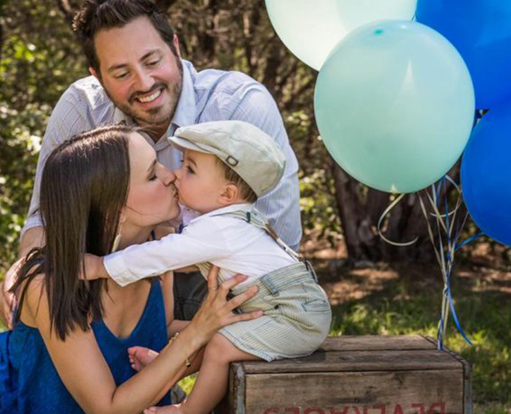 baby with mom and dad and balloons